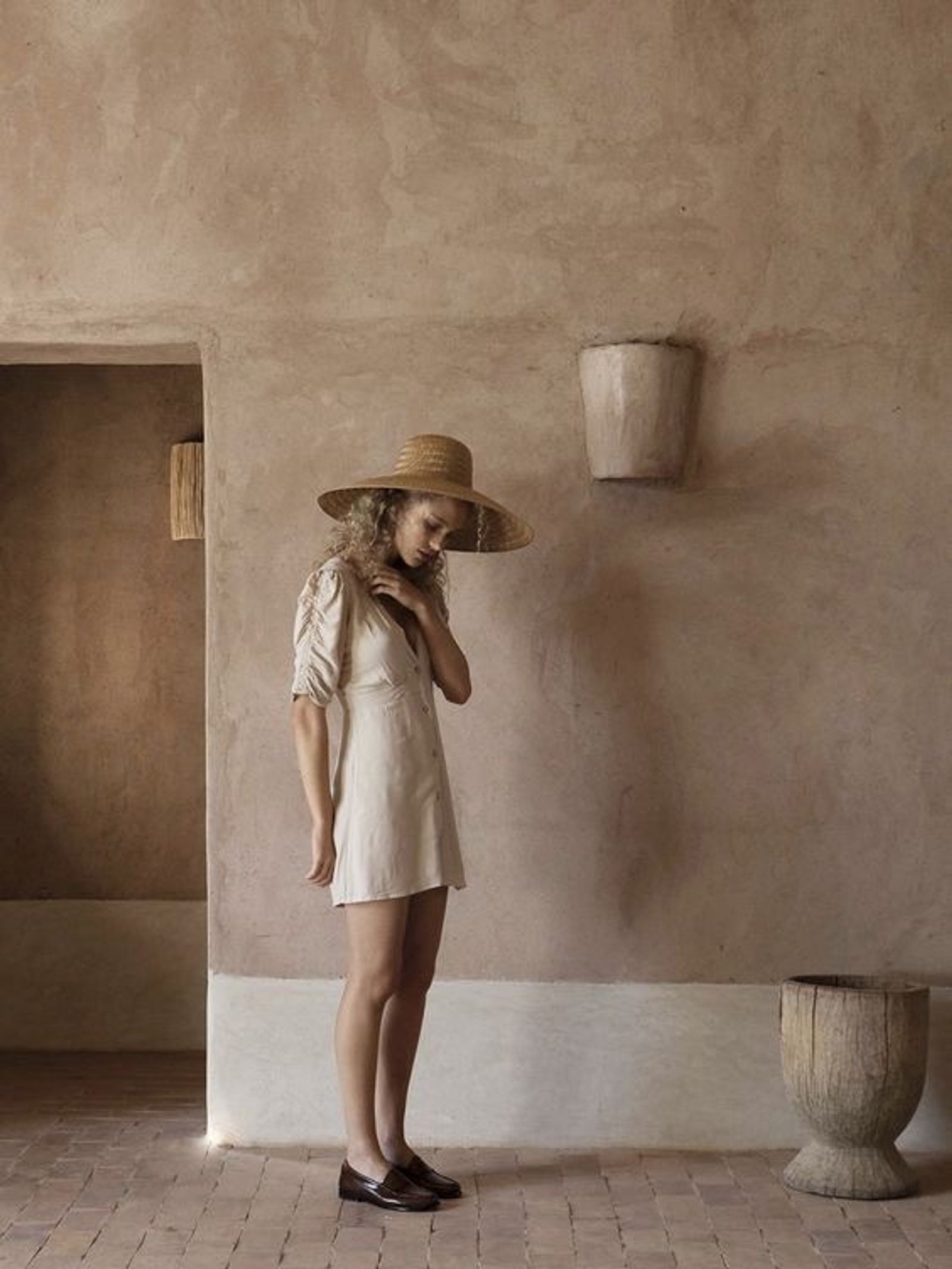 Woman in tadelakt interior with straw hat